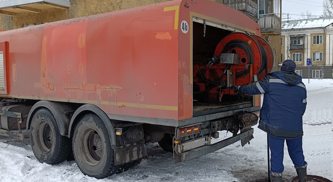 Каналопромывочная машина и работник прочищают засор в канализационной системе в Уве